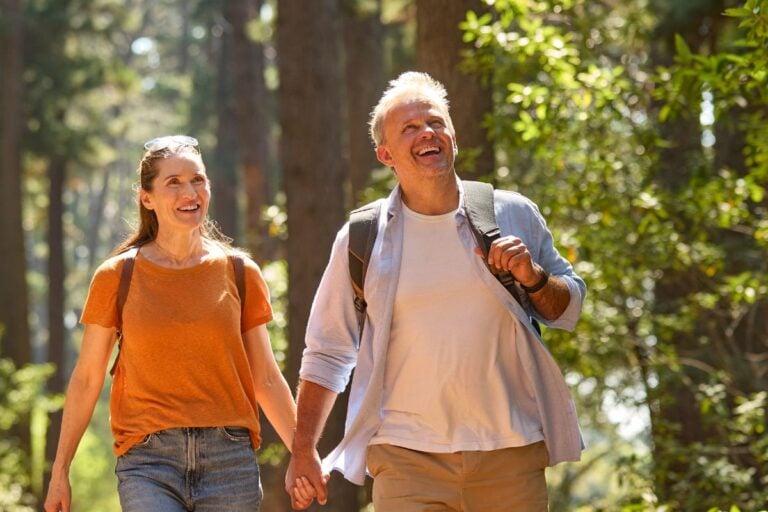 Older couple hiking a wooded trail